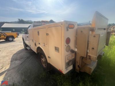 GMC Sierra 2500HD utility service body truck rear three-quarter view showing utility compartments and toolbox with tail lights and bumper.
