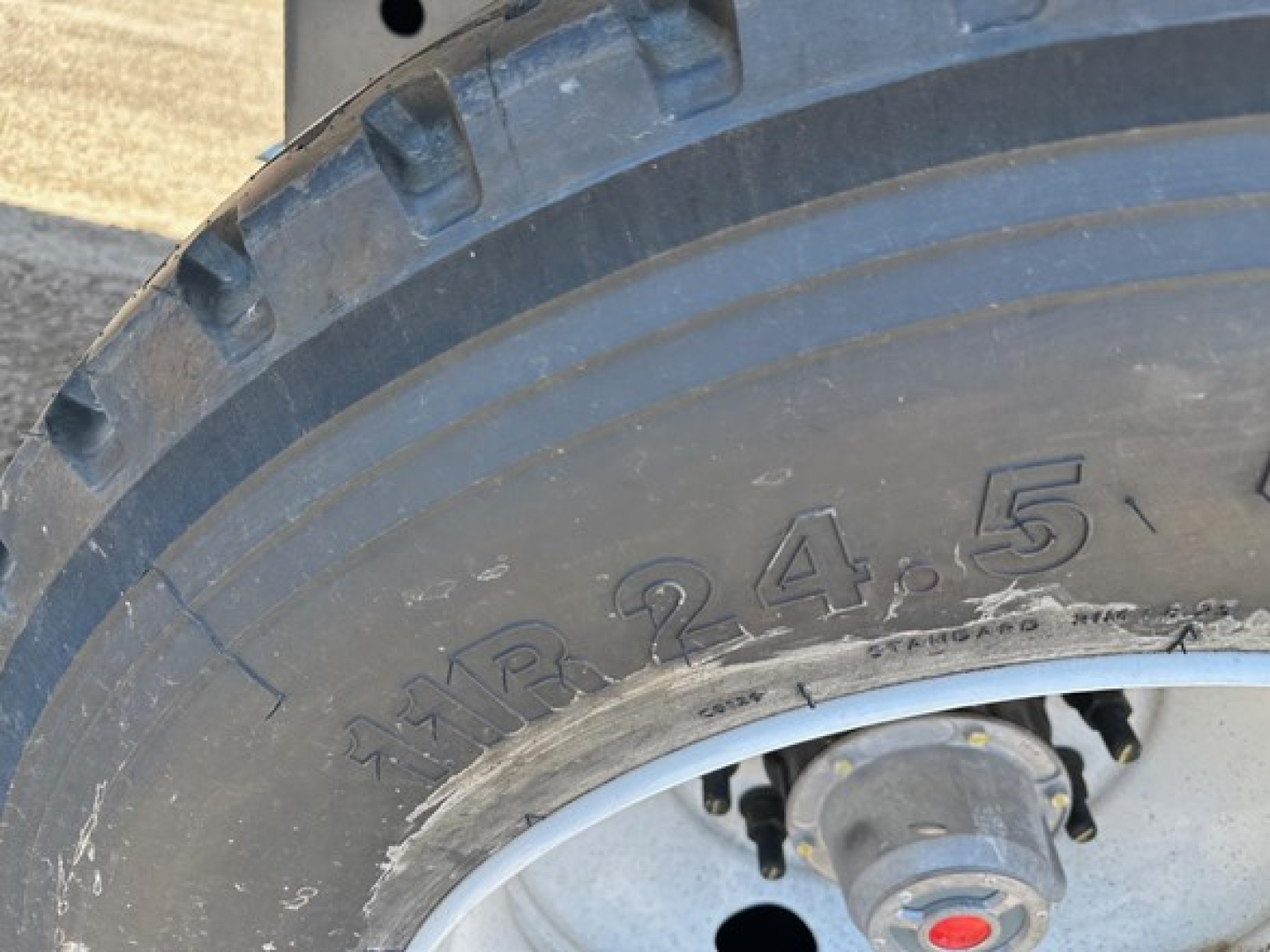 Wheel and tire of a trailer with embossed tire size markings '24.5' visible on sidewall.