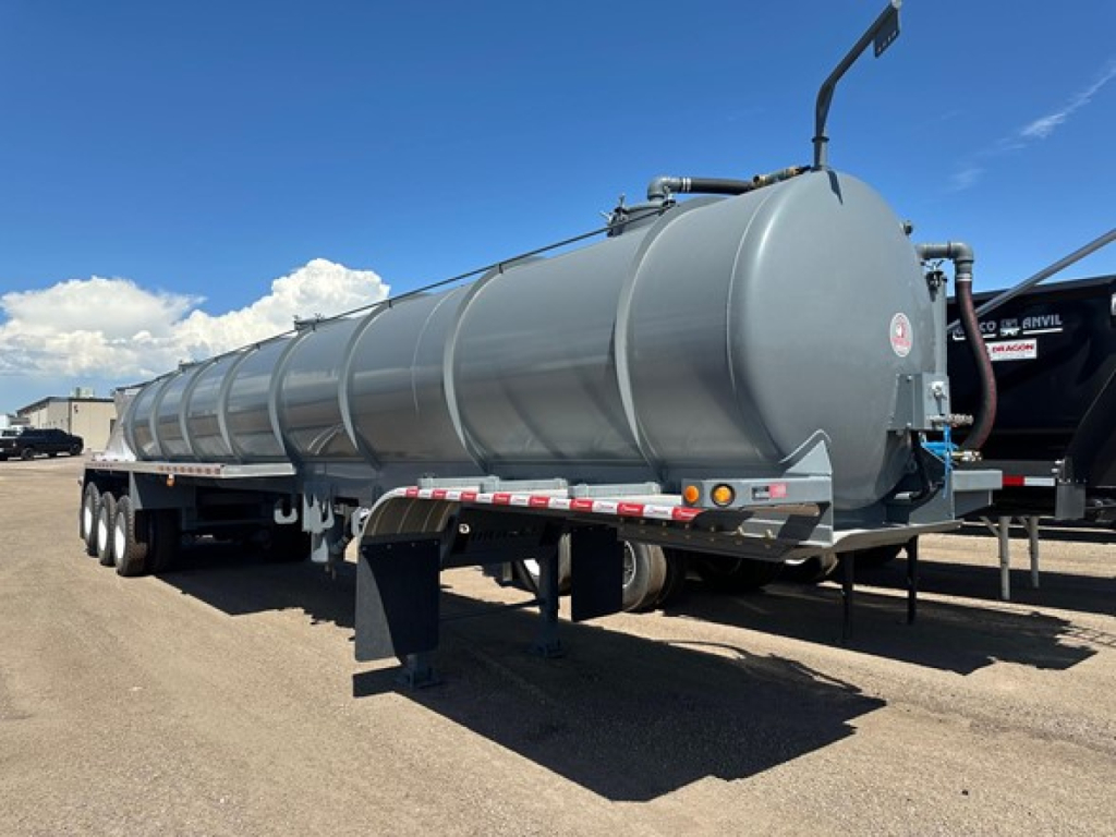 Vacuum water tank trailer with cylindrical tank on tri-axle chassis, grey color, rear connection and hoses visible.
