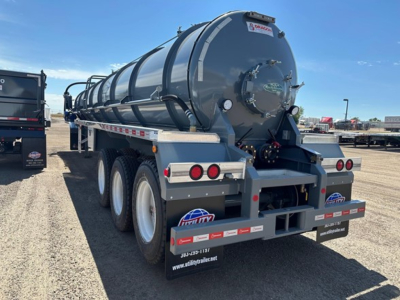 Vacuum water tank trailer with three-axle rear, cylindrical tank, rear access hatch, and safety reflectors showing NE11538 sticker and Utility trailer brand.