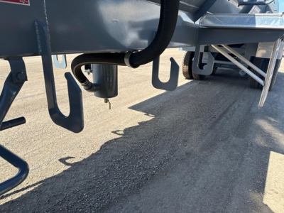Trailer undercarriage showing hoses and hooks for a vacuum water tank trailer