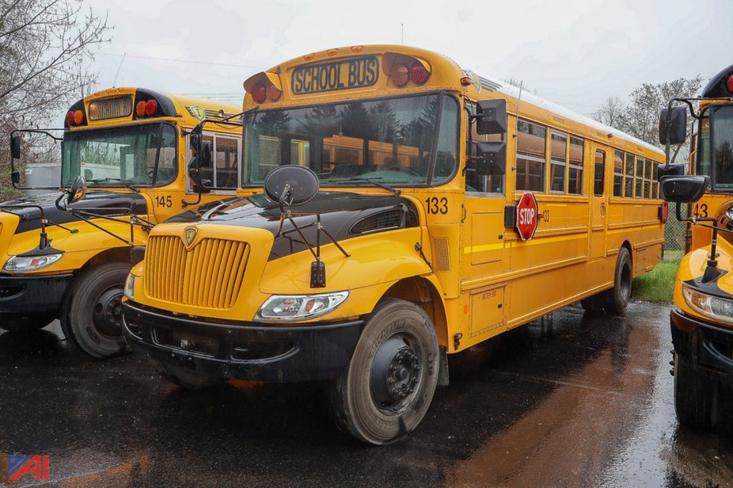 IC Corporation CE Series school bus with number 133, yellow exterior, front grille, and stop sign visible, parked among similar buses.