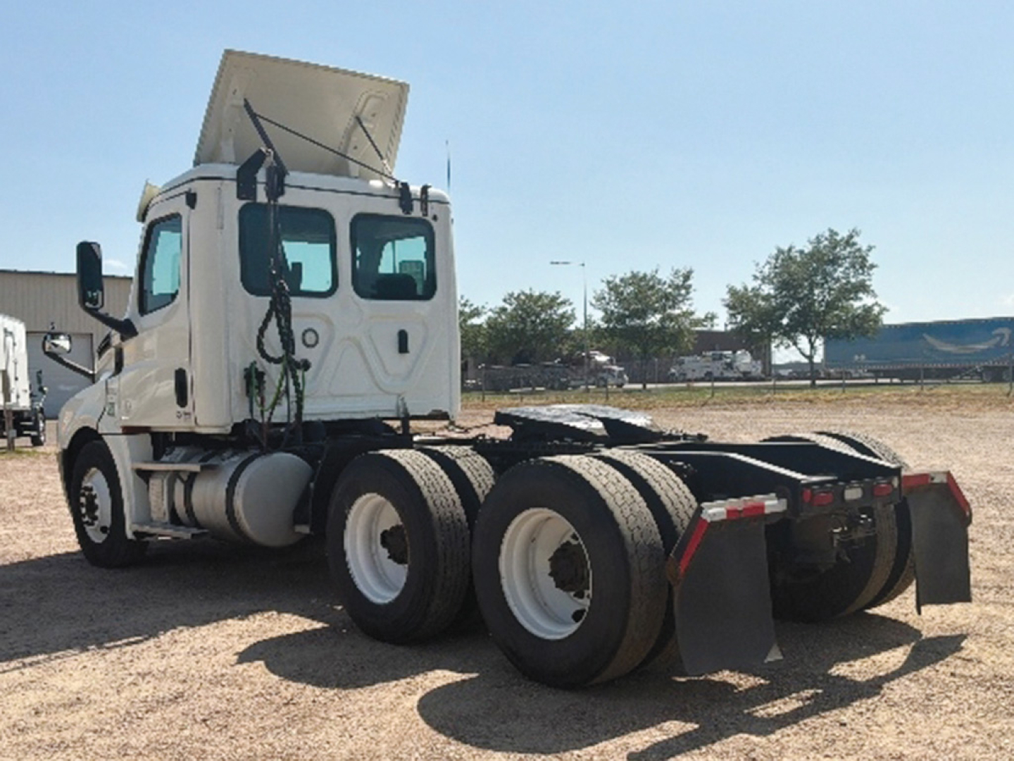 Truck cab view of a 2019 Freightliner Cascadia126 daycab, rear view shows dual rear axles and fifth wheel, VIN 3AKJGLDV3KSKF1982 not visible in image.