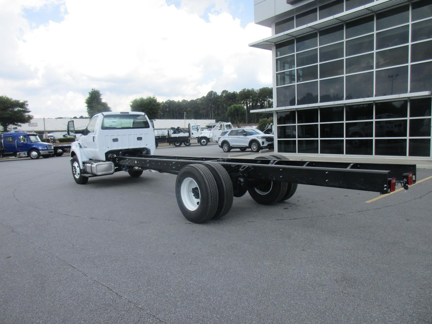 Ford F750 SD cab and chassis chassis frame with long wheelbase, white cab, in dealership lot.