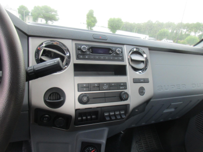 Dashboard and center console of a Ford F-750 Cab and Chassis showing digital radio, climate controls, and steering column.