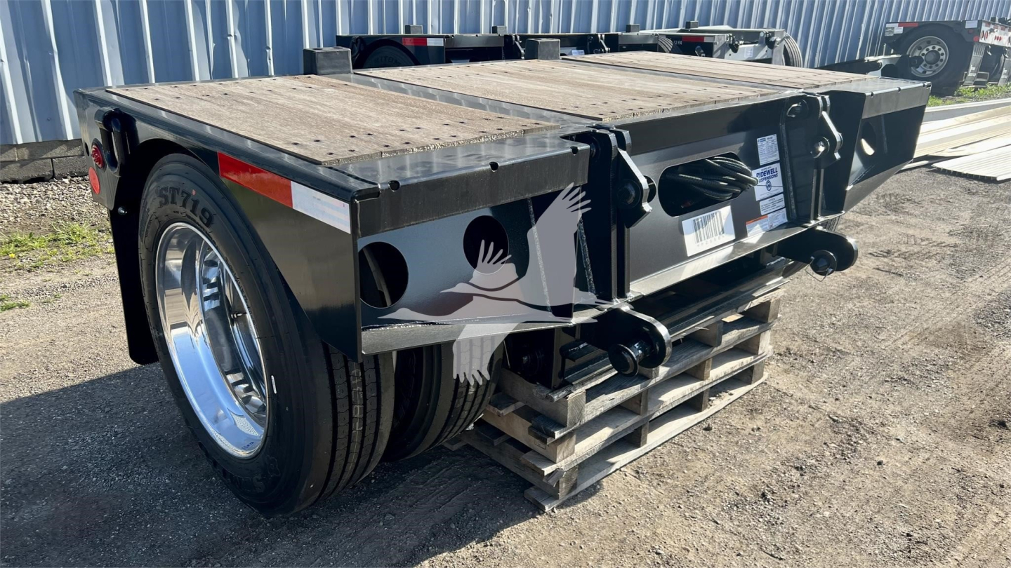 Trailer rear view showing lowboy deck and dual axles on Fontaine Renegade trailer with spare spaces and hydraulic hitch components.
