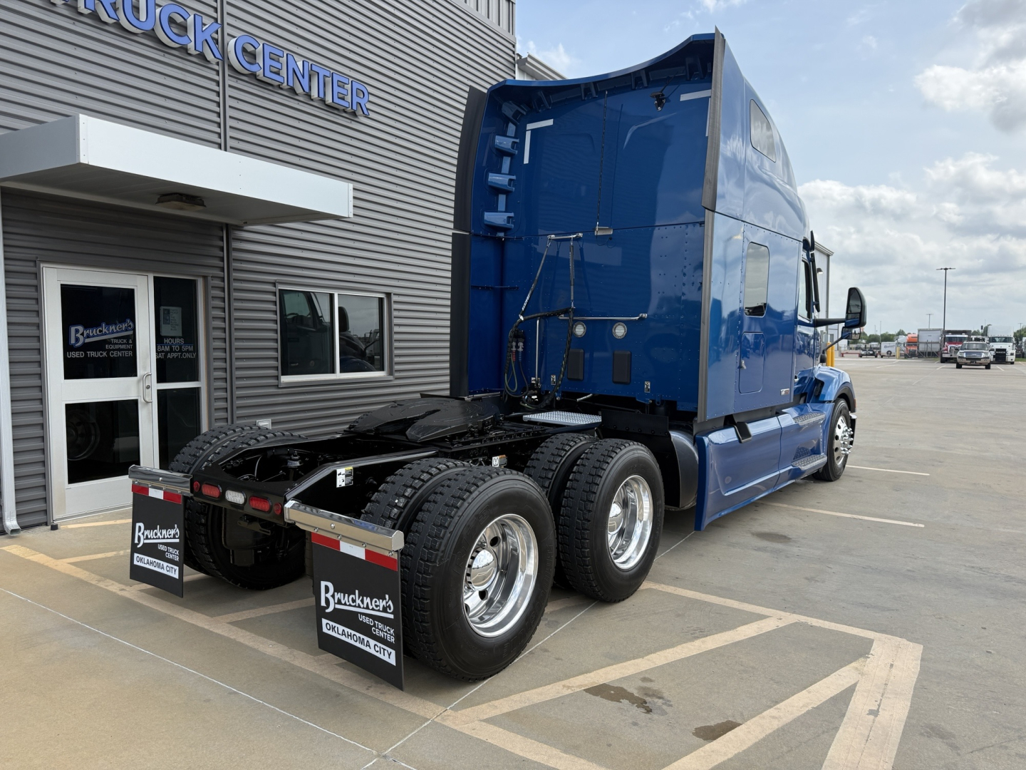 Peterbilt 579 truck in blue, rear view showing fifth wheel and dual rear axles, stock number B3163P, VIN 1XPBD49X0ND770704, conventional sleeper tractor at dealership.