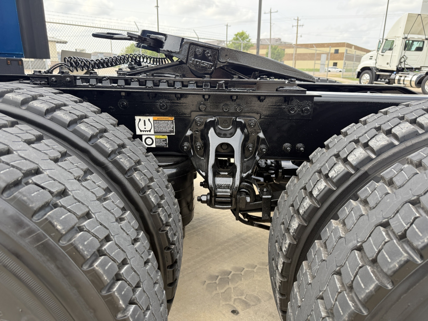 Peterbilt 579 truck chassis showing dual rear axles and suspension components, with visible frame, tires, and hitch area.