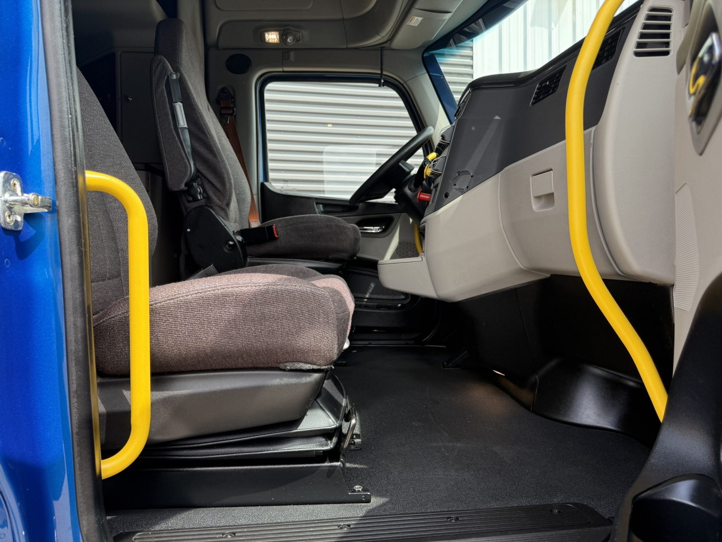 Peterbilt 579 truck interior cab view showing driver's seat and dashboard area.