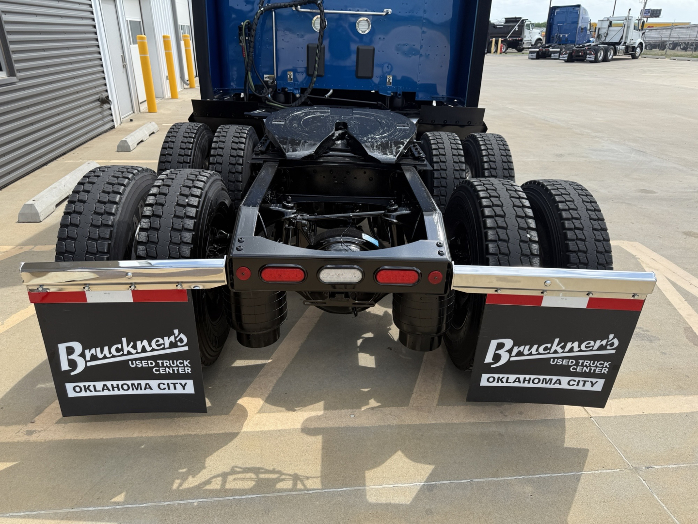 Peterbilt 579 tractor rear view showing dual rear axles with mud flaps labeled Bruckner’s Used Truck Center Oklahoma City.