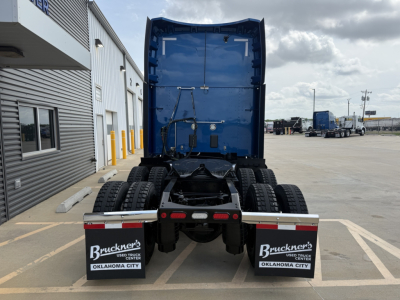 Peterbilt 579 (2022) rear view showing drivetrain with dual rear axles and blue cab, Bruckner's Oklahoma City mud flaps.