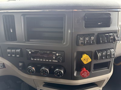 Peterbilt 579 dashboard area showing HVAC controls, radio, dashboard switches, and yellow and red ABS/engine knobs.