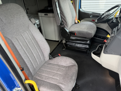 Peterbilt 579 truck cab interior showing gray fabric seats, steering wheel, and driver's area.
