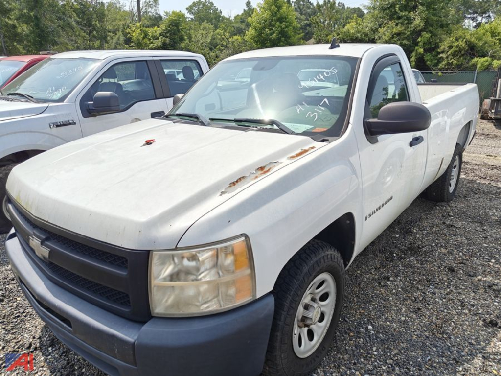 Chevrolet Silverado 1500 single-cab pickup in white with front-right view, showing hood damage and side mirrors; pickup bed visible in used condition.