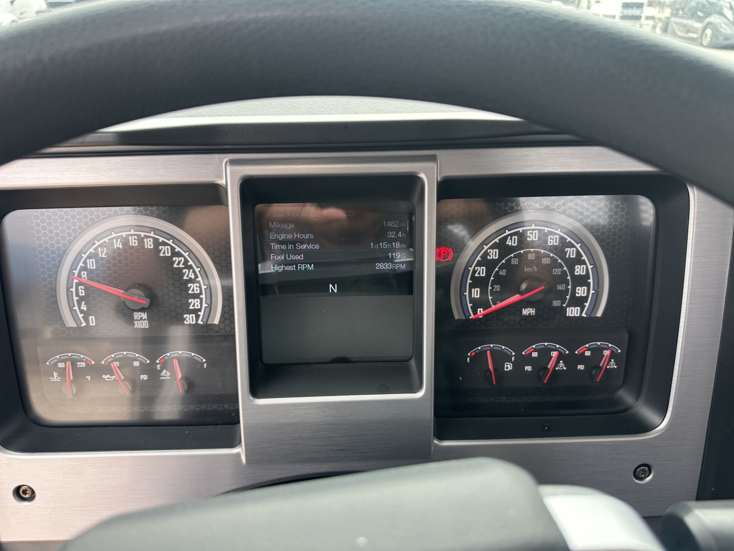 Dashboard of a Mack MD6 truck showing instrument cluster with speedometer 0-120 mph, tachometer, and central display screen. Various indicators and gauges are visible.