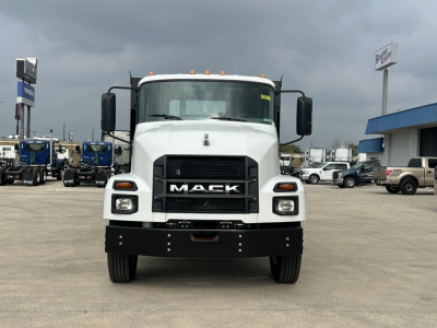Front view of a white 2026 Mack MD6 flatbed truck showing bold grille with MACK logo, headlights, and bumper.