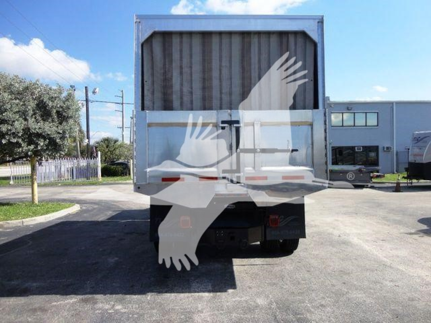 Truck tailgate of a 2023 International MV dump truck viewed from rear showing the bed and chassis; stock number MVEXCABCHIP16 indicated in the listing.