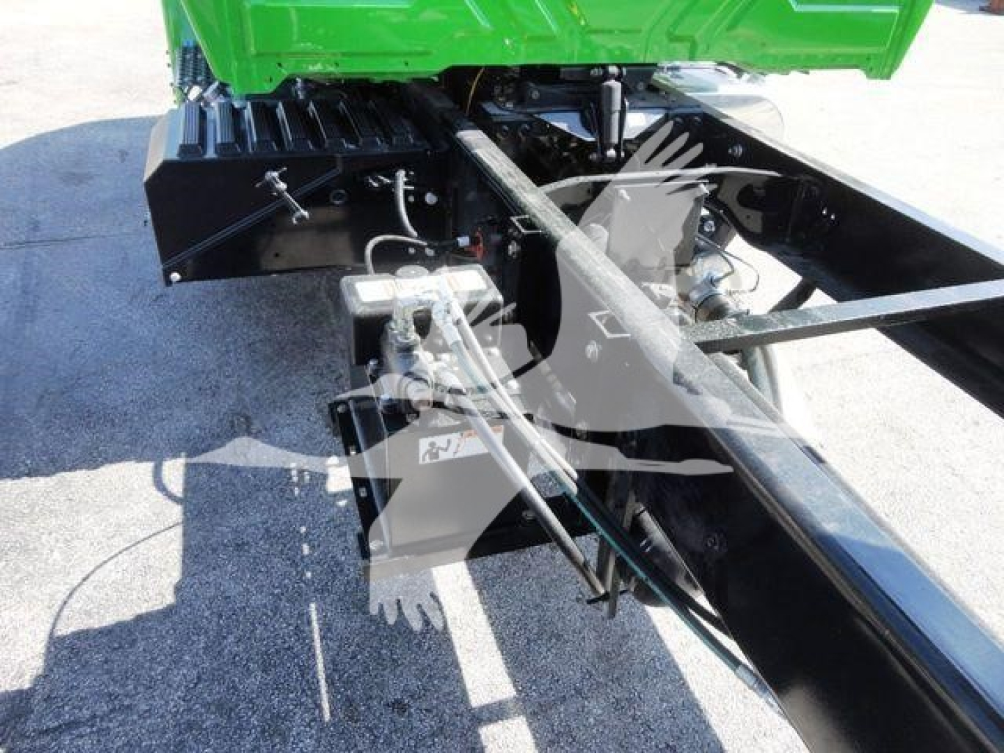 Chassis view of a 2023 International MV chipper truck showing hydraulic lines and frame components.