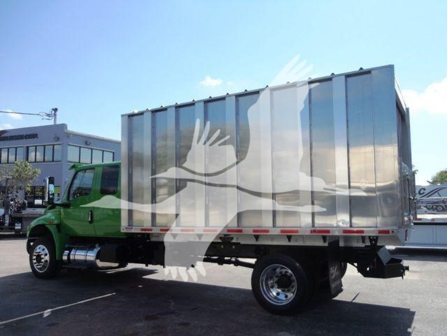 Truck at a dealership showing a silver cargo box on a green International MV cab. Visible text includes stock number MVEXCABCHIP16 and category/type hints in listing.