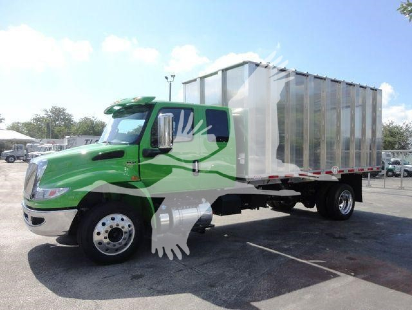 Green International MV truck with a large aluminum dump bed, front grille, curved hood, and dual rear wheels, parked in lot. Visible text not legible on vehicle.