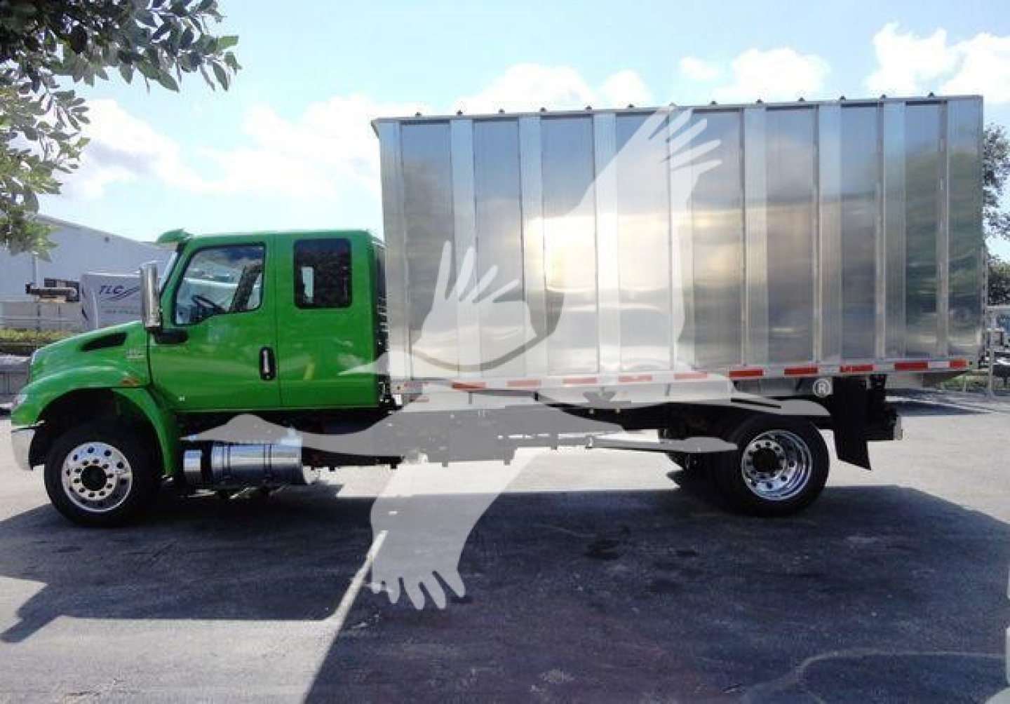 International MV truck with green cab and silver cargo box, side view showing chassis and wheels.
