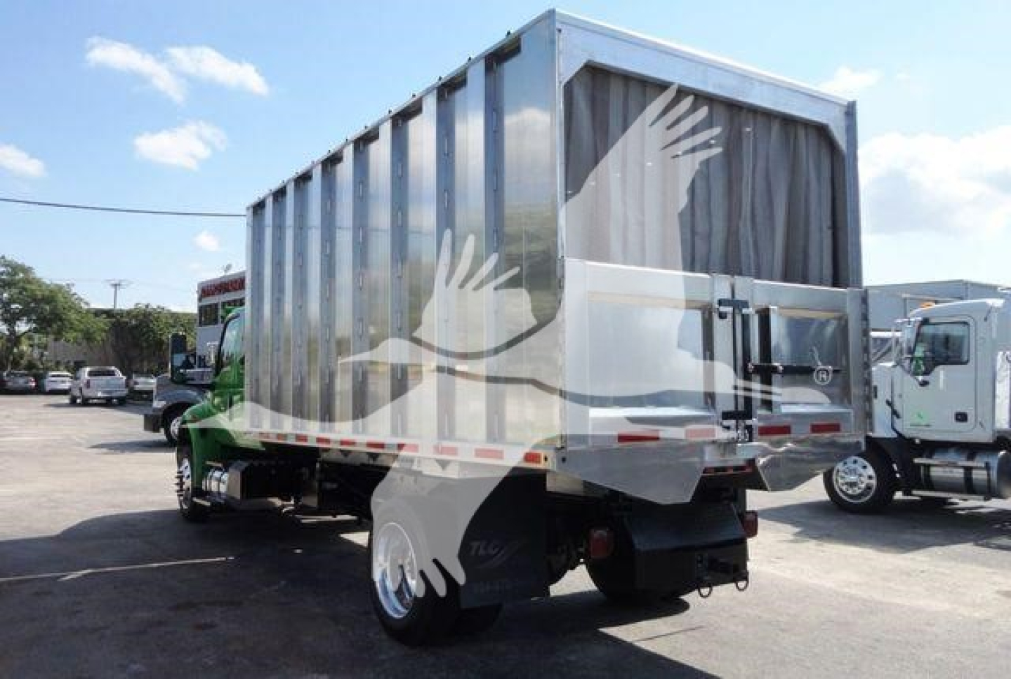 Truck chassis with an aluminum dump body showing rear and side, MVEXCABCHIP16 stock number, new International MV chipper truck.
