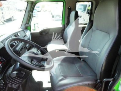 Interior of a 2023 International MV truck cab showing steering wheel, driver seat, and passenger seat in view.