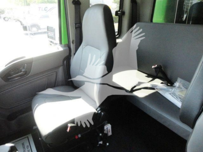 Cab interior of a 2023 International MV truck showing front seat and passenger bench with grey upholstery and minimal detailing.