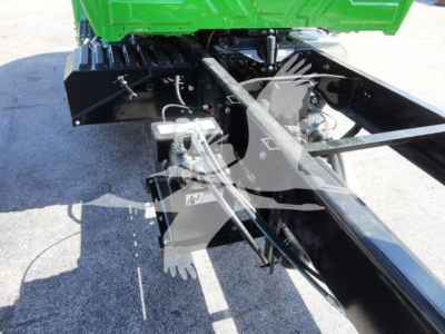 Chassis view of a 2023 International MV chipper truck showing hydraulic lines and frame components.