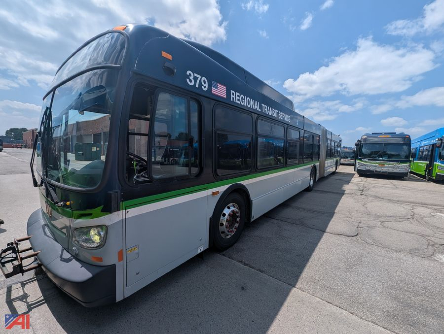 Transit bus 2013 New Flyer Xcelsior regional transit service with 379 number, green stripe, large windows, parked with other buses.