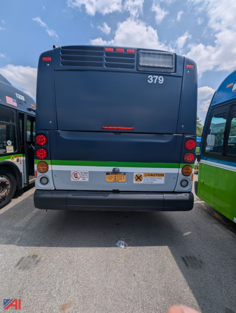 Rear view of a blue 2013 New Flyer Xcelsior transit bus showing bus number 379, taillights, rear bumper, and warning decals.