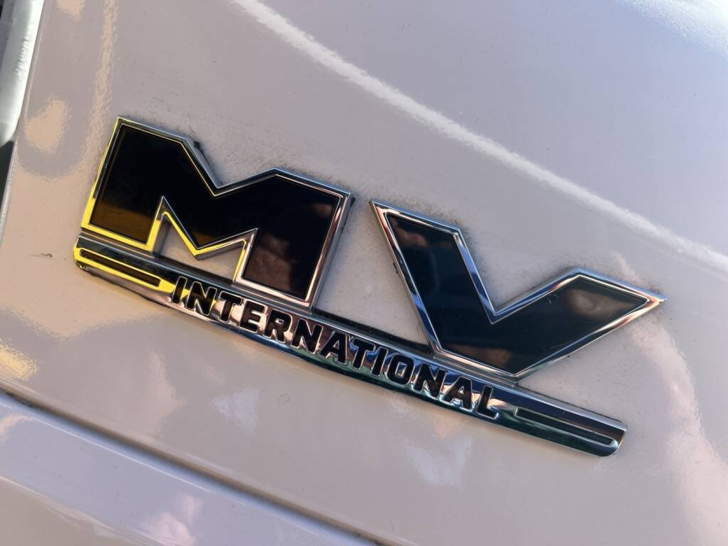 M/V International emblem on truck cab showing MV logo and International text badge.