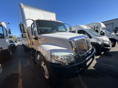Truck front-left view of a 2020 International MV box truck showing front grille with chrome, large side mirrors, and white cargo box.