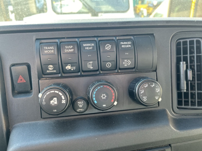 Dashboard controls of a 2020 International MV showing multiple buttons: TRANS MODE, SUSP DUMP, MIRROR HEAT, PARKED REGEN, and three climate control dials with icons.