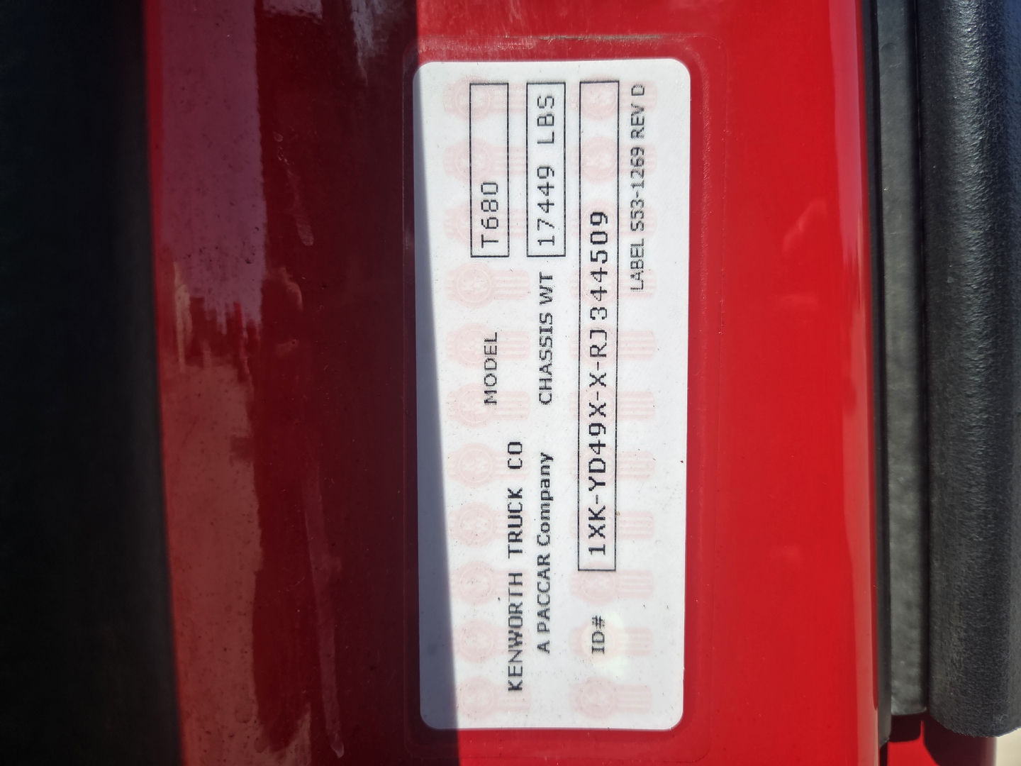 Label on Kenworth T680 door jamb showing model T680, chassis weight 1744 LBS, rear axle 1XKYD49XXRJ344509, and stock/rev info.