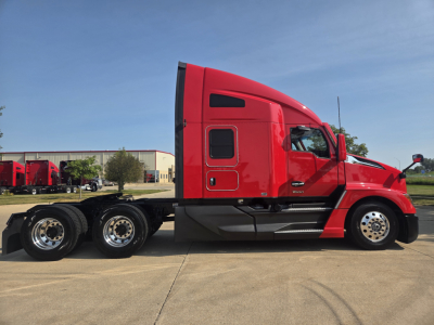 Kenworth T680 side view showing sleeper cab and chassis with triple rear axles in red