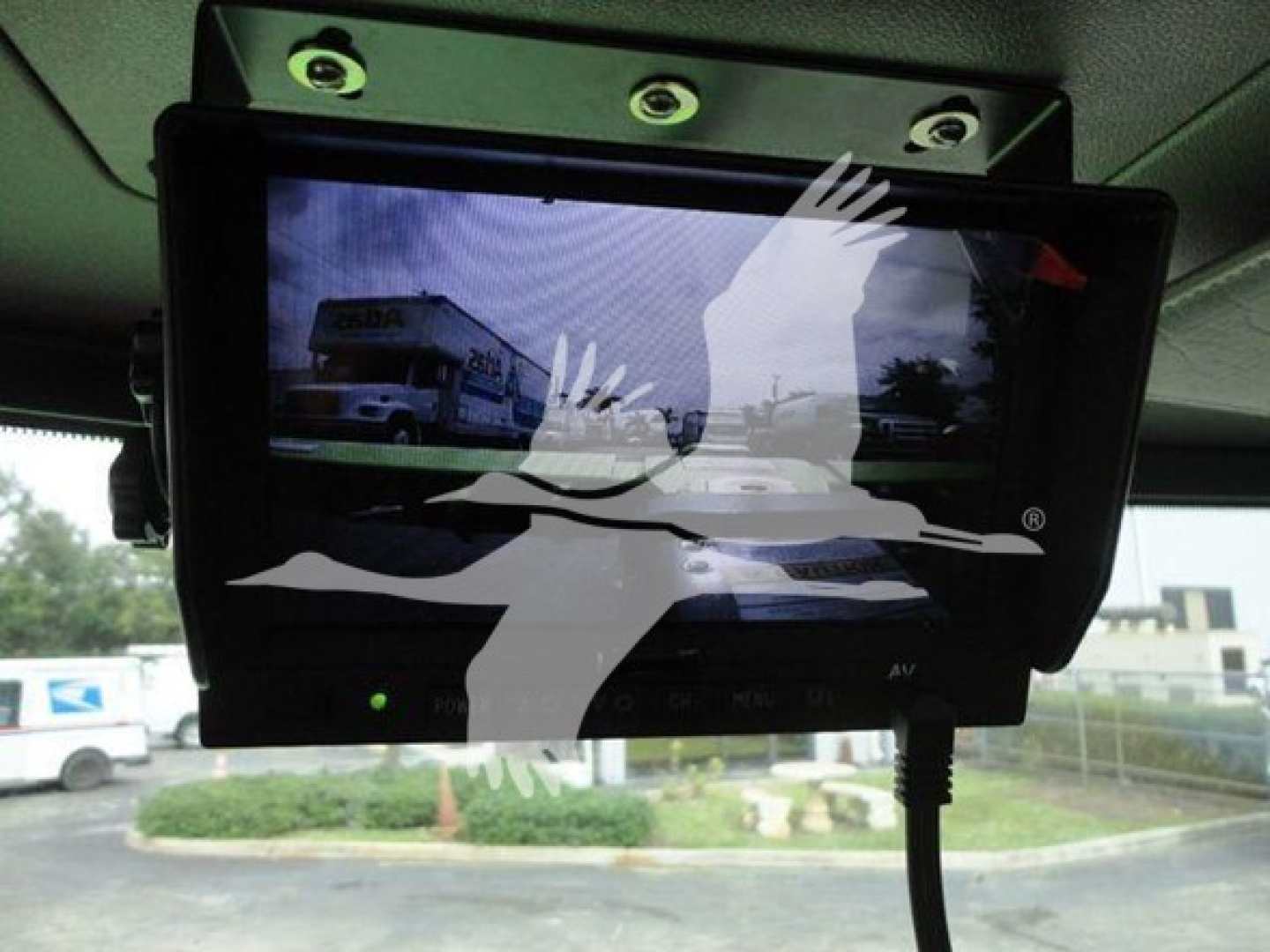 Truck monitor/display mounted in Peterbilt 337 cab showing a reflection of a rollback truck in the screen.