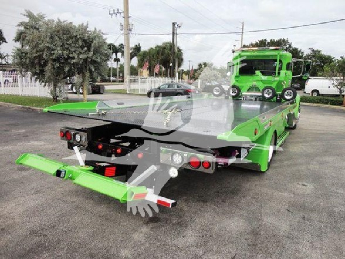 2022 Peterbilt 337 rollback truck with green color, rear view showing flatbed with loading ramps and hitch, VIN tag and stock number not visible from this angle.