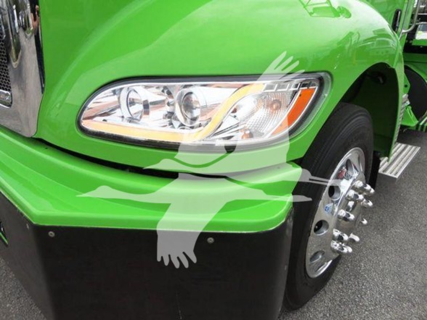 Green Peterbilt truck front fender with headlight and chrome wheel assembly; no readable text visible on the image portion.