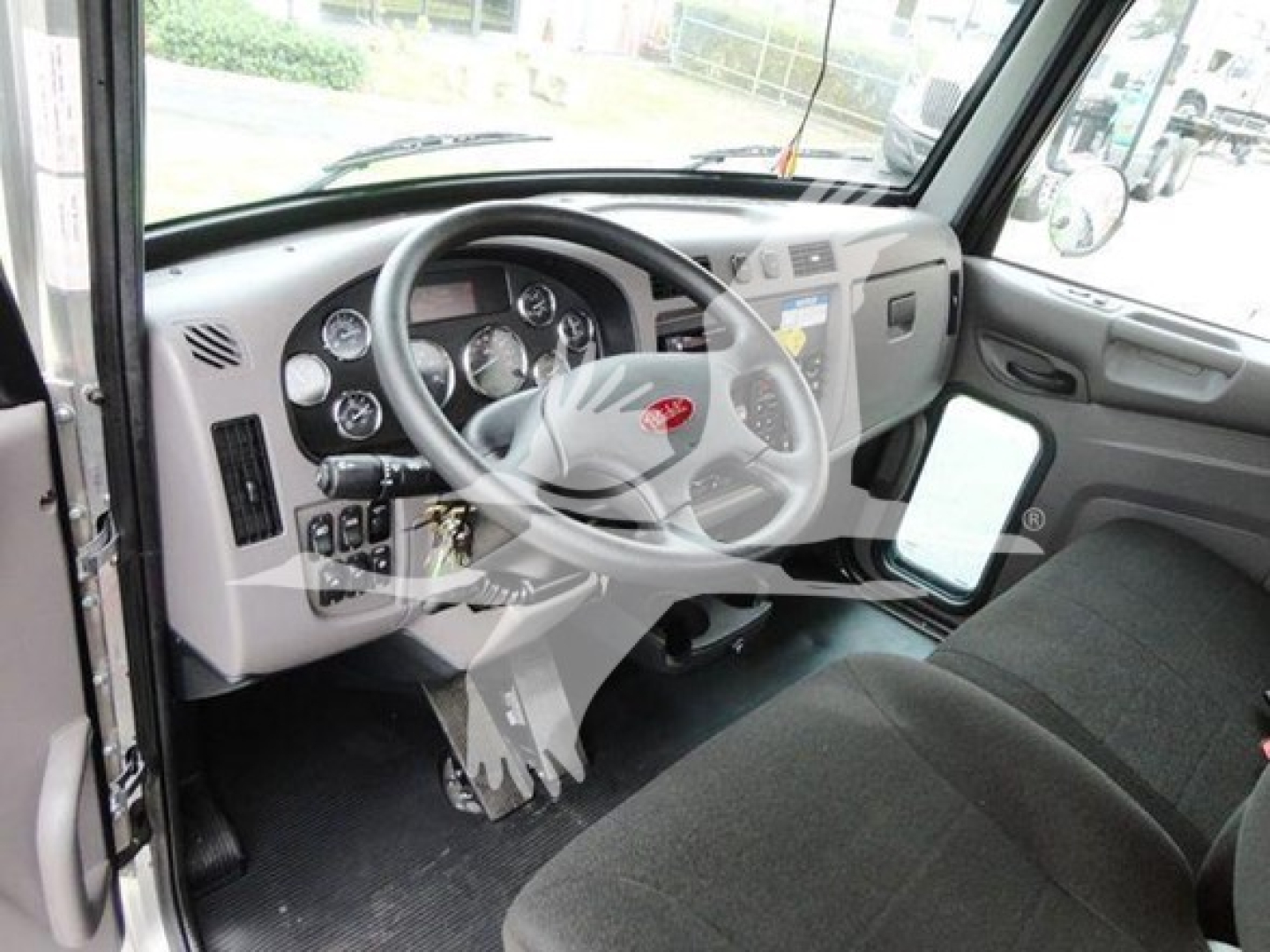 Peterbilt 337 dashboard and steering wheel interior showing gauges, steering wheel, dash controls, and passenger seat.