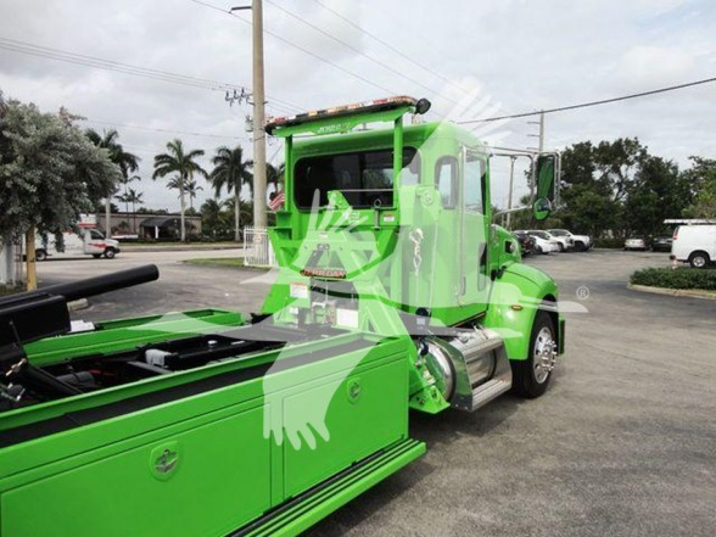 Peterbilt 337 rollback wrecker truck in lime green, front cab visible, hydraulic tow boom extended, side mirror, chrome wheels.