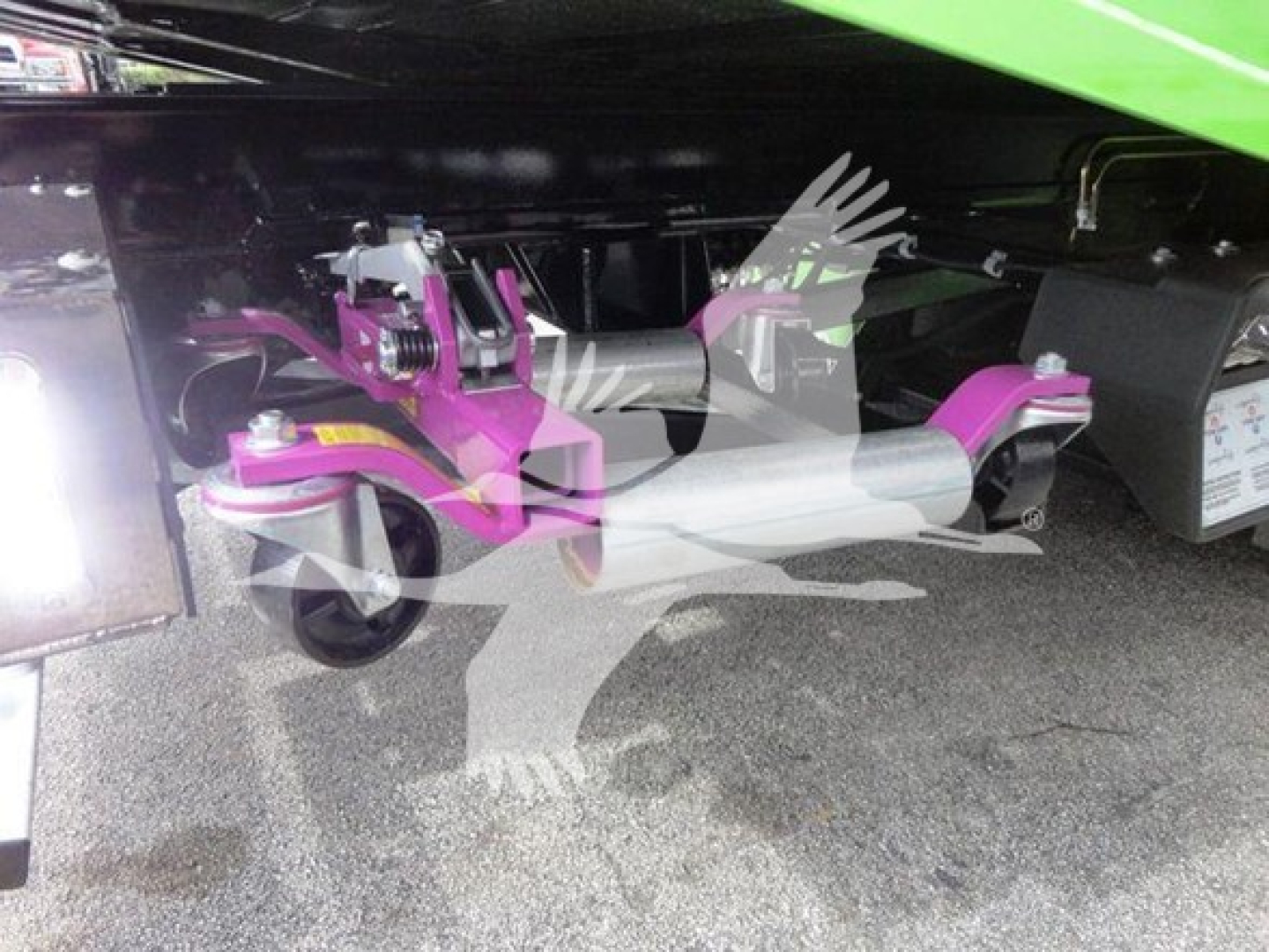 Underbody view of a 2022 Peterbilt 337 rollback truck showing a purple hydraulic lift mechanism and undercarriage components.
