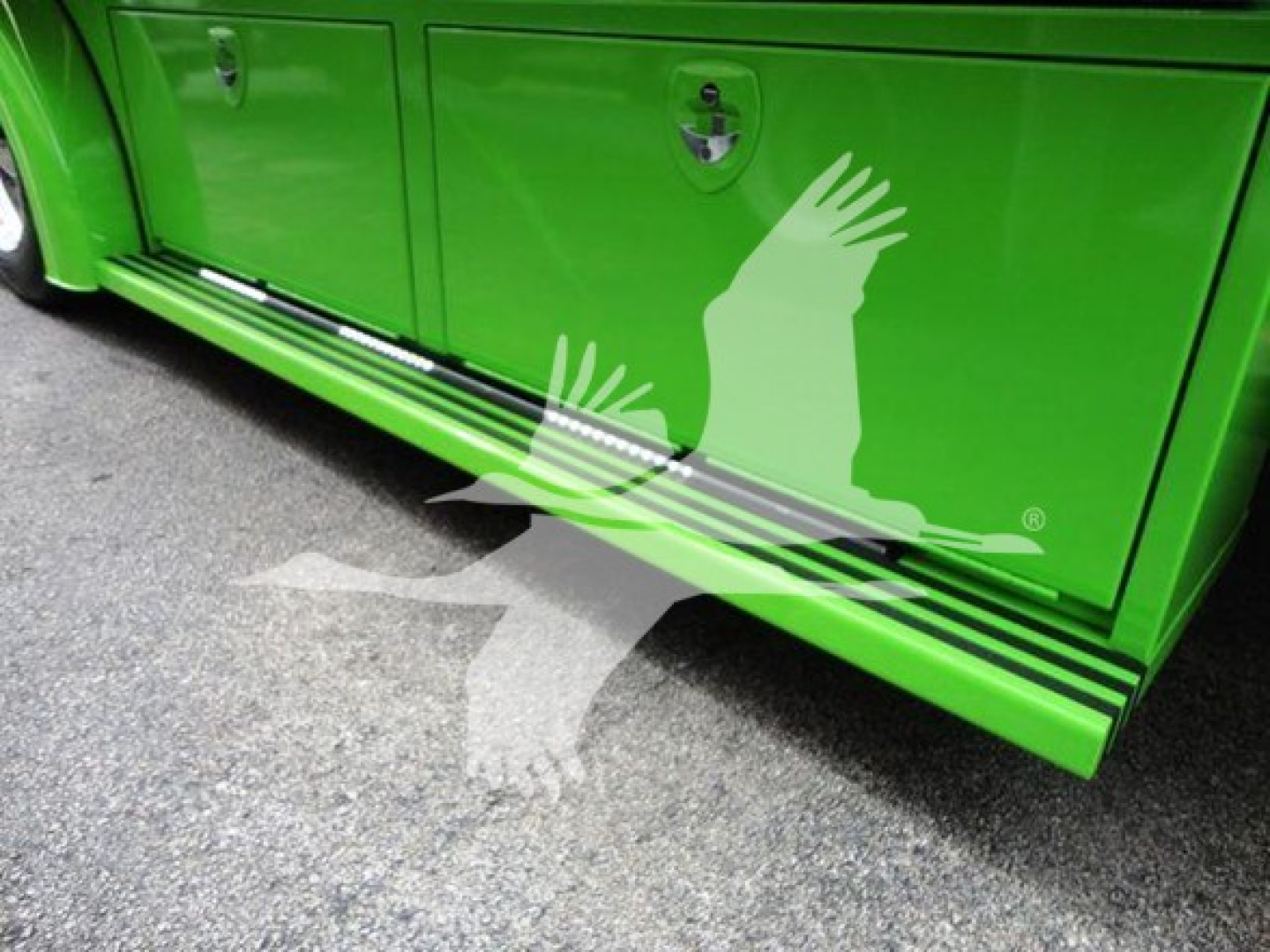 Petersbilt 337 side toolboxes with green paint and a whitewing graphic on lower side; lower side step rails visible.