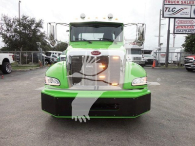 Front view of a green 2022 Peterbilt 337 rollback truck showing large front bumper and grille; no visible text readable on the hood.
