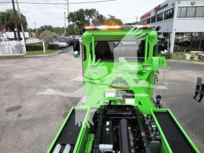 Green Peterbilt rollback truck cab from rear/above with black bed components and warning lights; no legible labels visible on image surface.