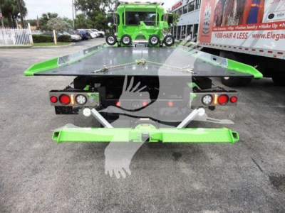 Green rollback tow truck platform rear view with hydraulic tilt and dual LED taillights.
