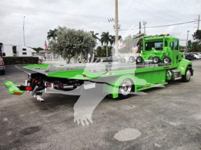Green Peterbilt 337 rollback truck with flatbed and tow vehicle on a dealership lot; VIN 2NP2HM6XXNM762011 and stock J62011 visible; new condition.