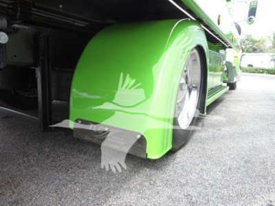 Peterbilt 337 rollback truck wheel well and bright green fender with graphic. Visible: wheel, fender, undercarriage, and side step area.