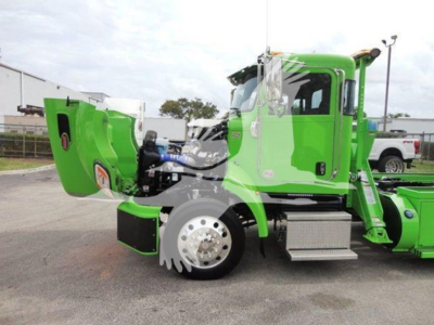 Peterbilt 337 rollback truck in green with cab and wheel, side view showing large chrome wheel and side step.