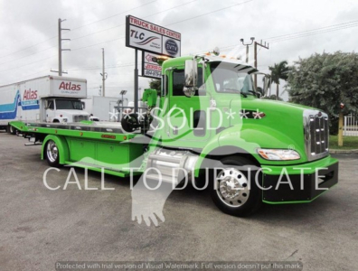 Green Peterbilt 337 rollback truck side view with 'SOLD' watermark, visible text includes 'Truck Sales Center' sign, 'Atlas' logo on trailer, and 'CALL TO DUPLICATE' watermark.